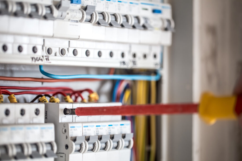 man electrical technician working switchboard with fuses installation connection electrical equipment close up scaled
